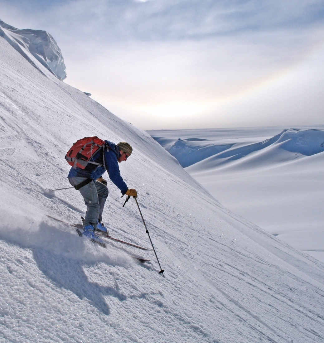Skier descending powdery slope in Antarctica
