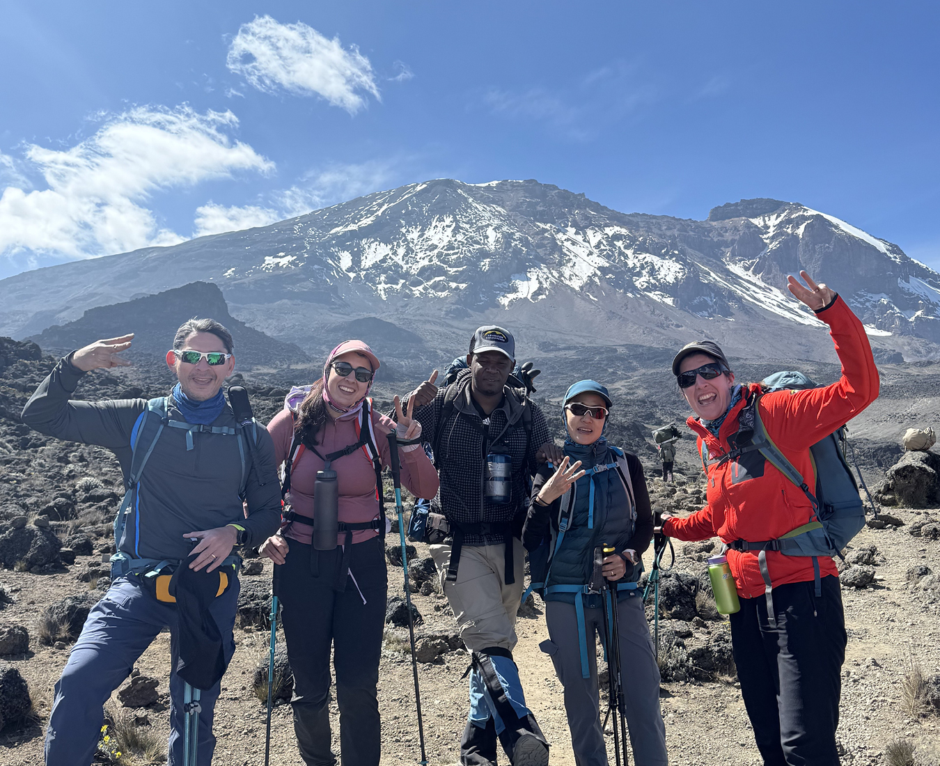 Day 3 of the Kilimanjaro trek sees the team enroute to Barranco Camp, all smiles they line up for a photo with big smiles and brightly coloured jackets!