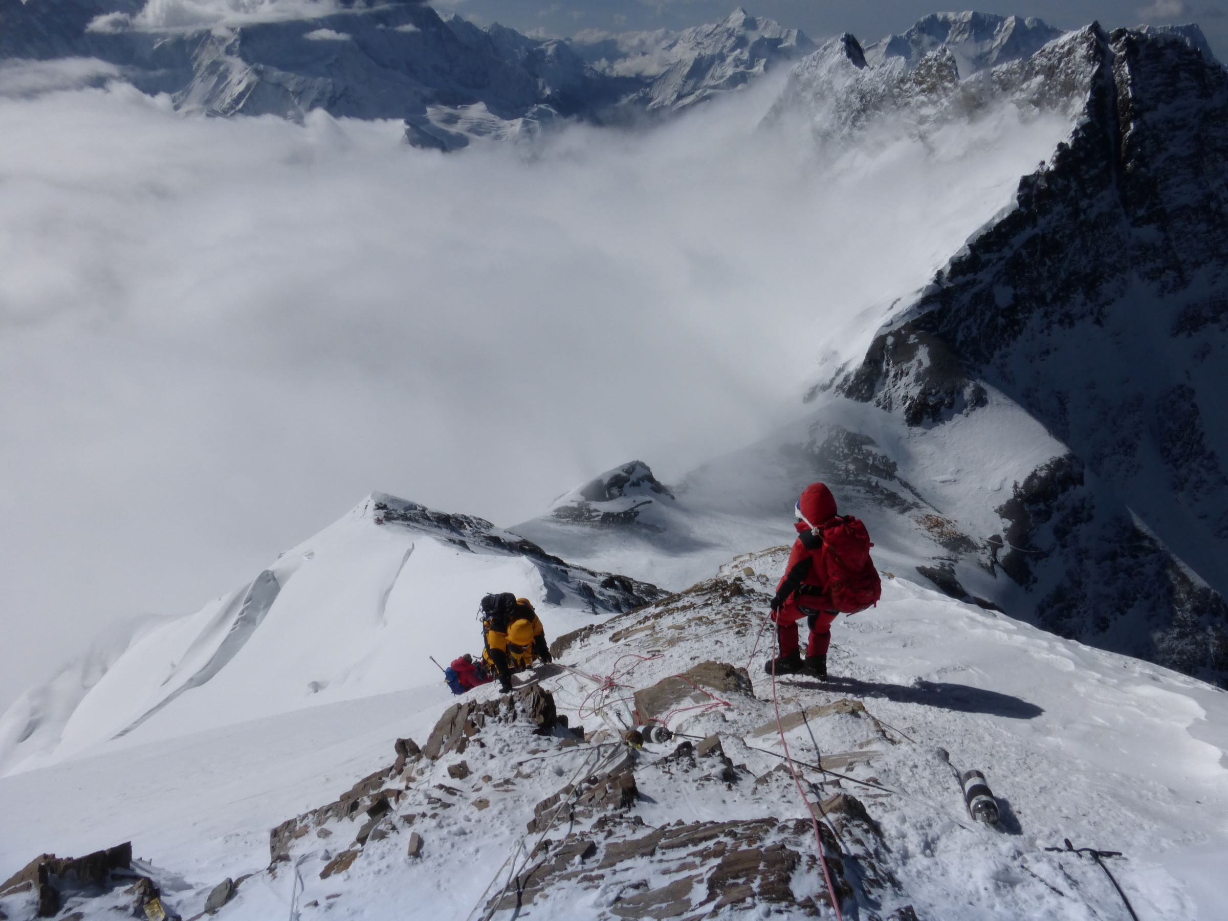 Climber waiting for team mates on fixed rope high on SE ridge Mt Everest