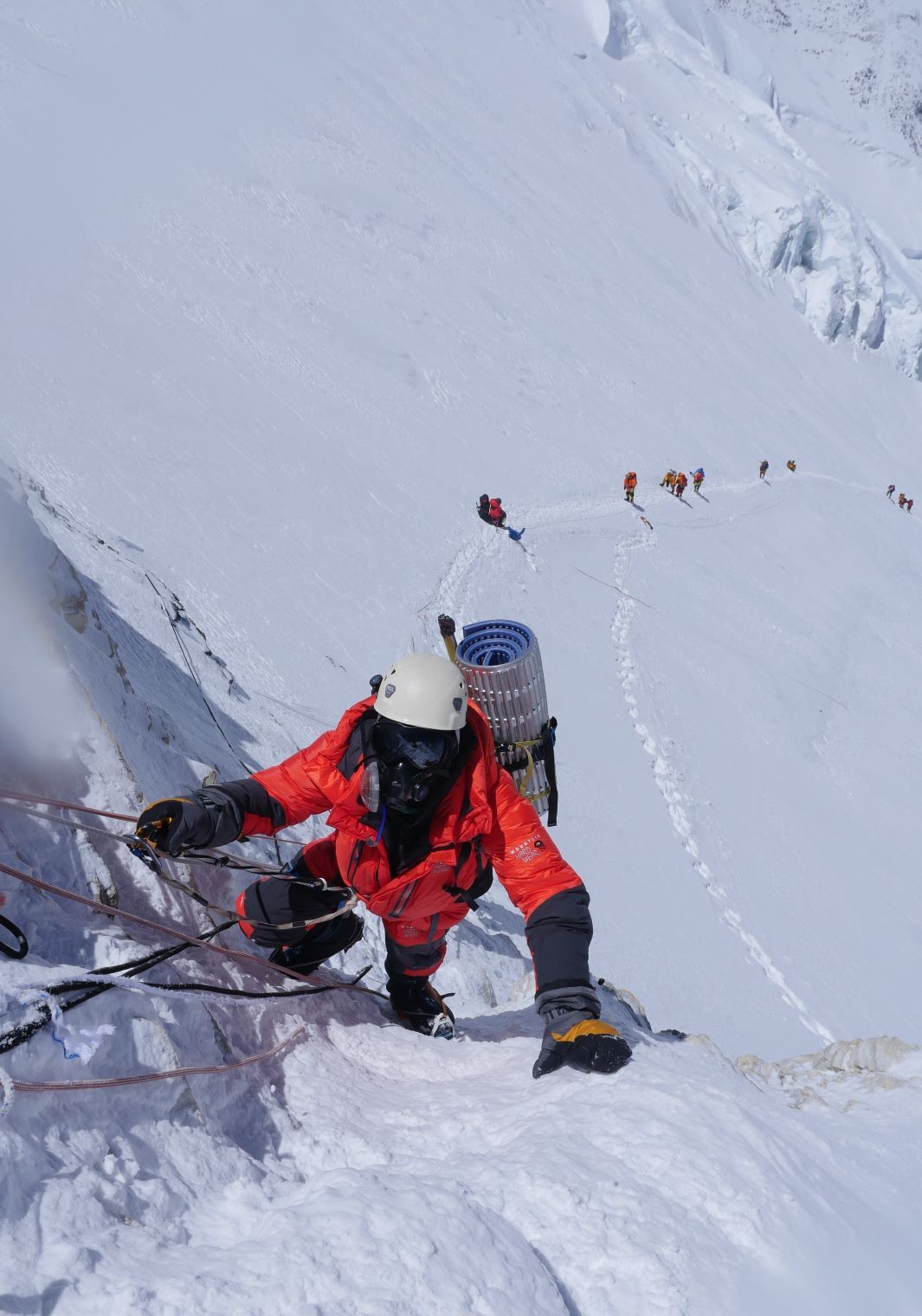 Climber in orange suit climbing the yellow band on the Lhotse face of Mt Everest